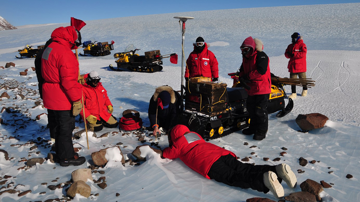 Parka-clad volunteers collecting a meteorite that fell in Antarctica