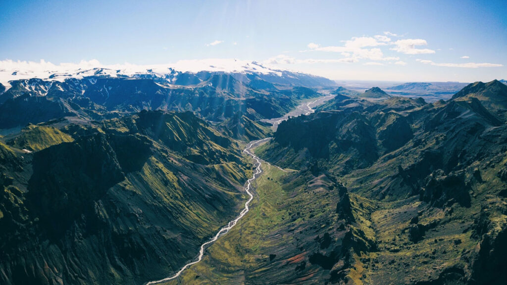 View looking down on a river valley under a blue sky in Iceland