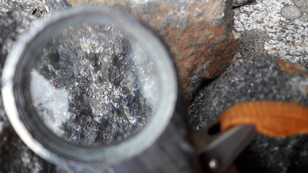A magnified view of white minerals embedded in a gray crustal rock