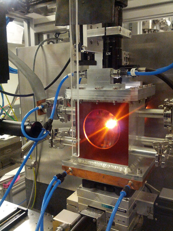 A sample is heated in the experimental chamber under vacuum as two diamond anvils within apply pressure.