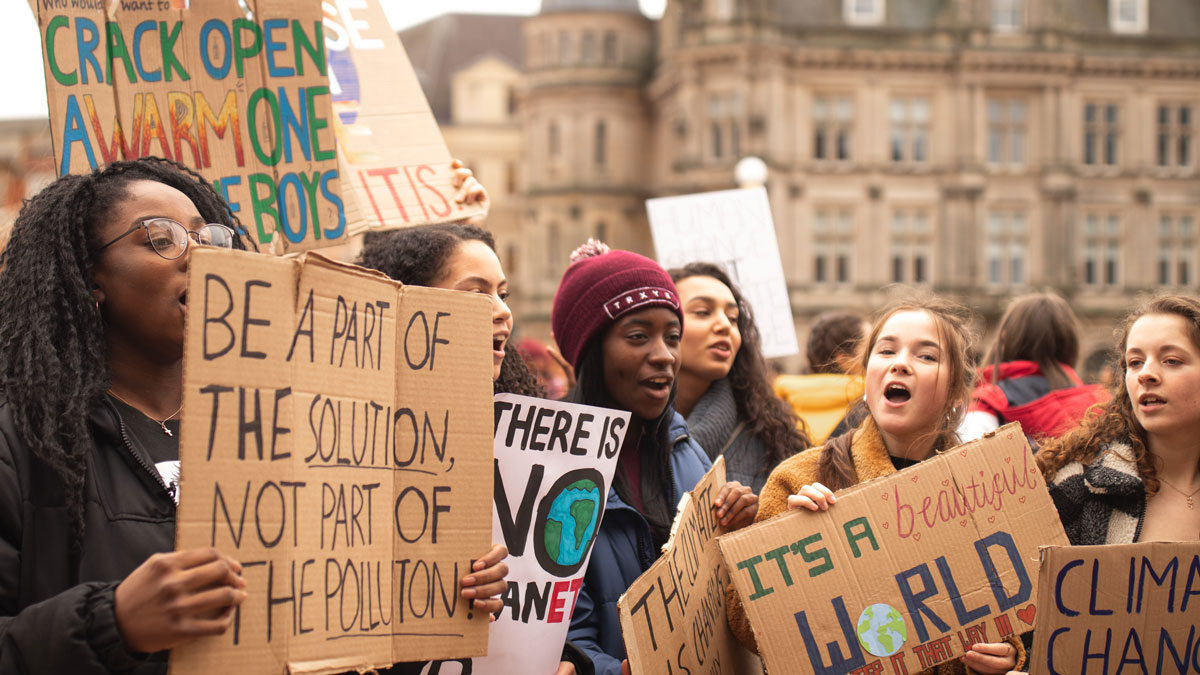 Protestors hold signs for climate action.