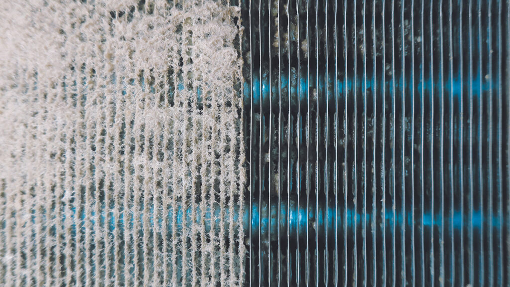 An air conditioner coil that has thick dust at left and is clean at right