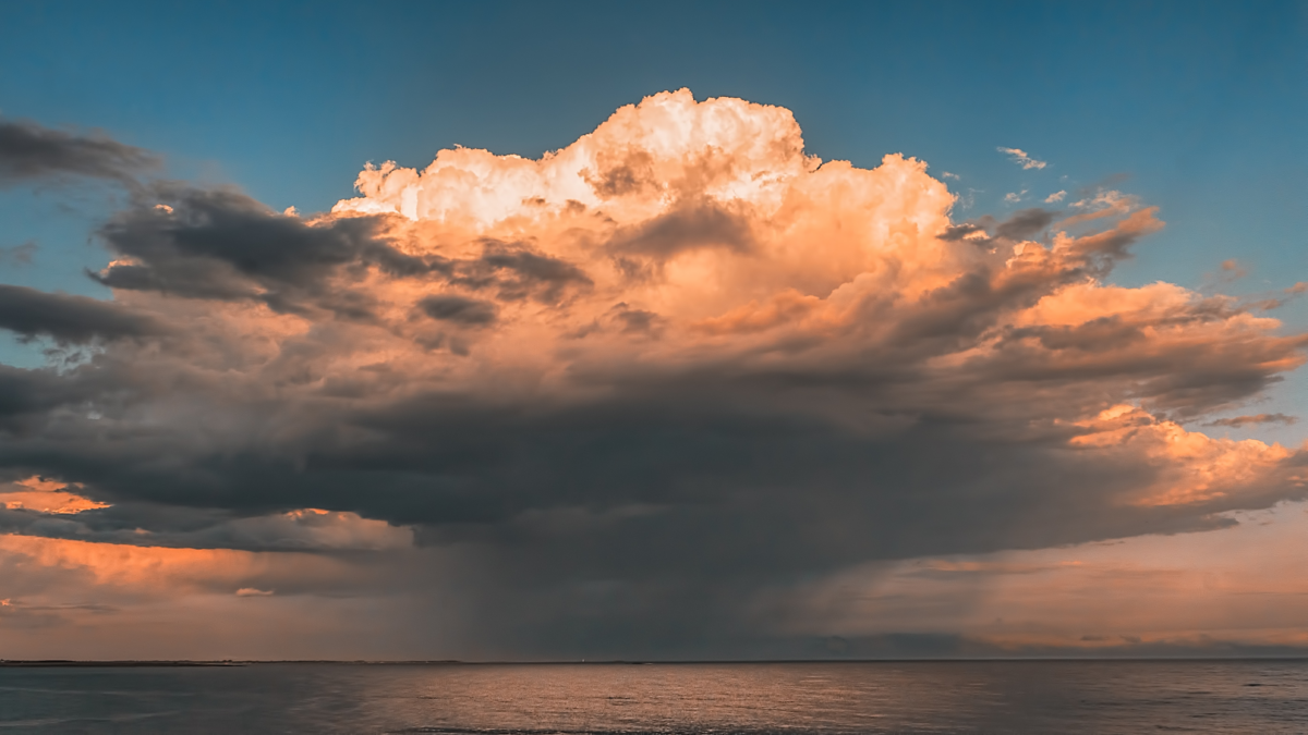 Photograph of a raincloud over an ocean.