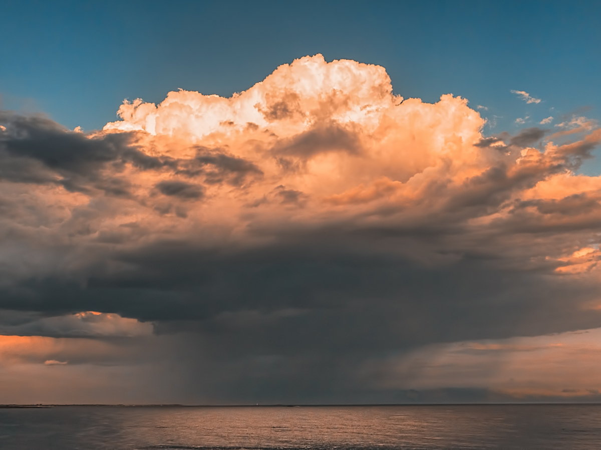 Photograph of a raincloud over an ocean.