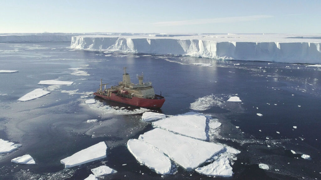 Icebreaker at work near glacier.