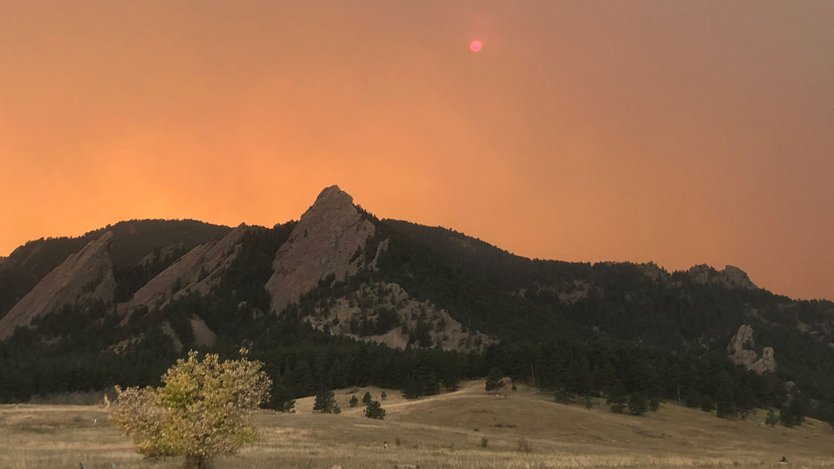 A hazy orange sky above a mountain range