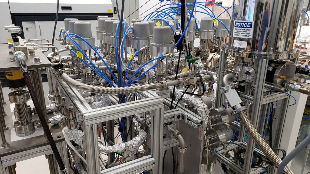 A complicated arrangement of laboratory pipes, tanks, wires, and other equipment.