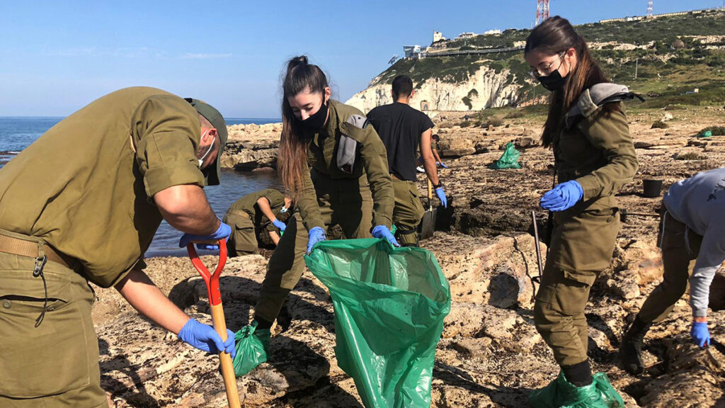 Israeli soldiers clean tar from the beaches in February 2021 after oil from a spill in the eastern Mediterranean washed ashore.
