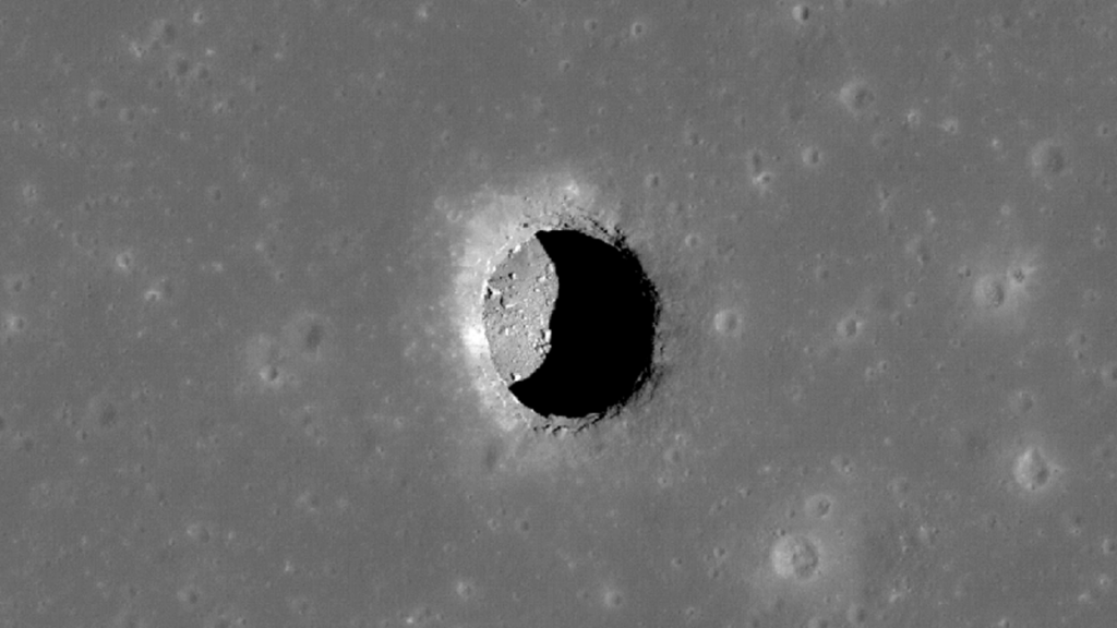 Black-and-white satellite image of a pit crater on the Moon.
