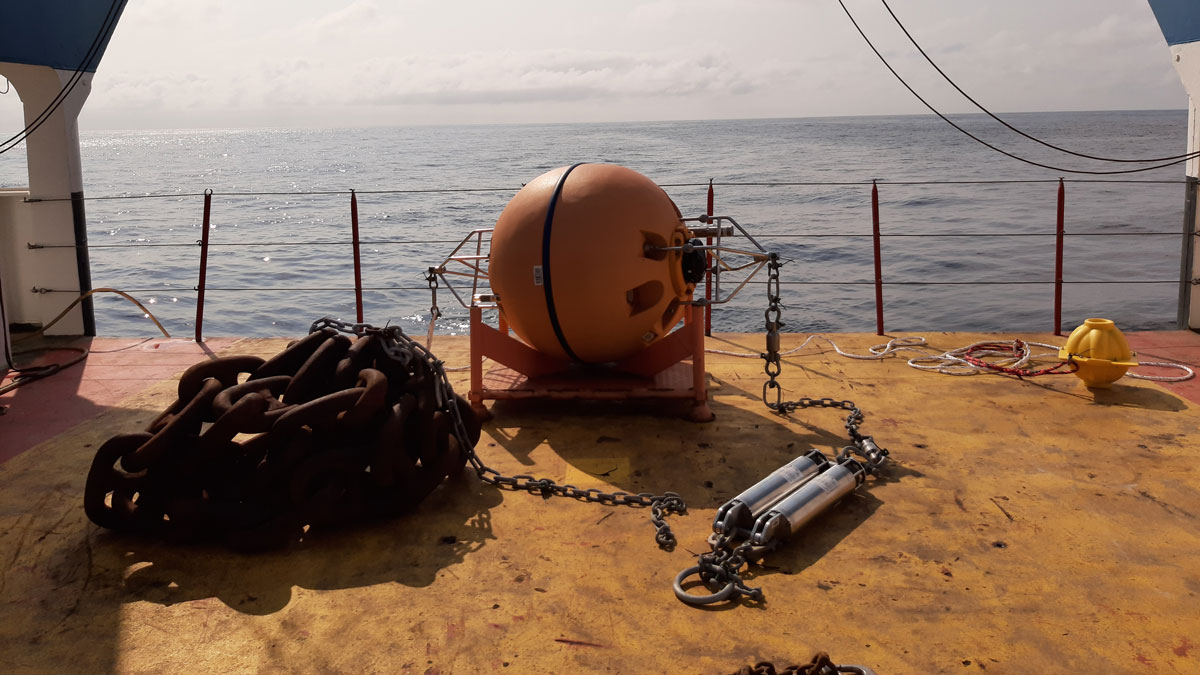 Sensors attached to an orange buoy on the deck of a research vessel