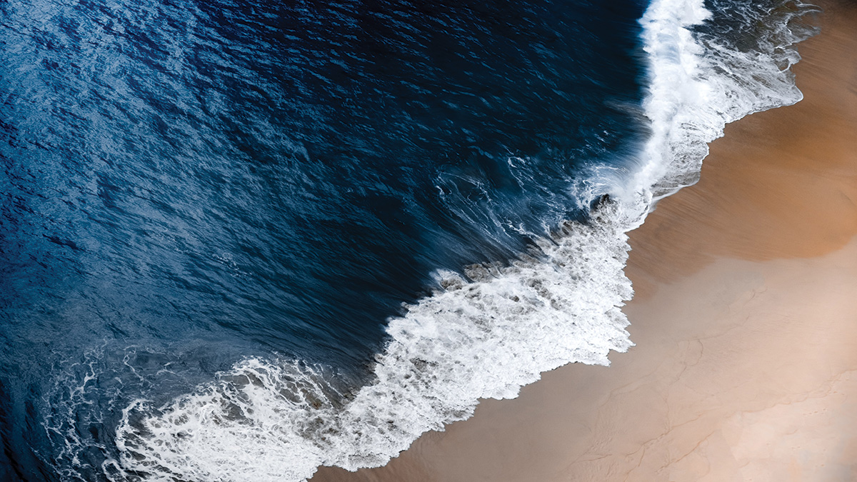 A wave washes ashore on a beach in Bali, Indonesia.