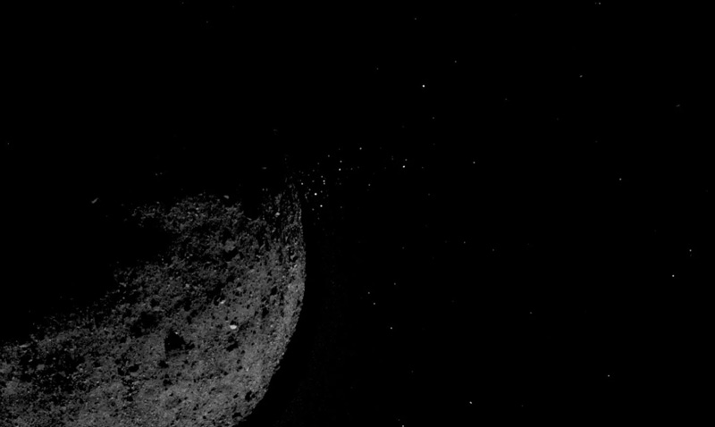 Small pebbles stream away from the asteroid Bennu.