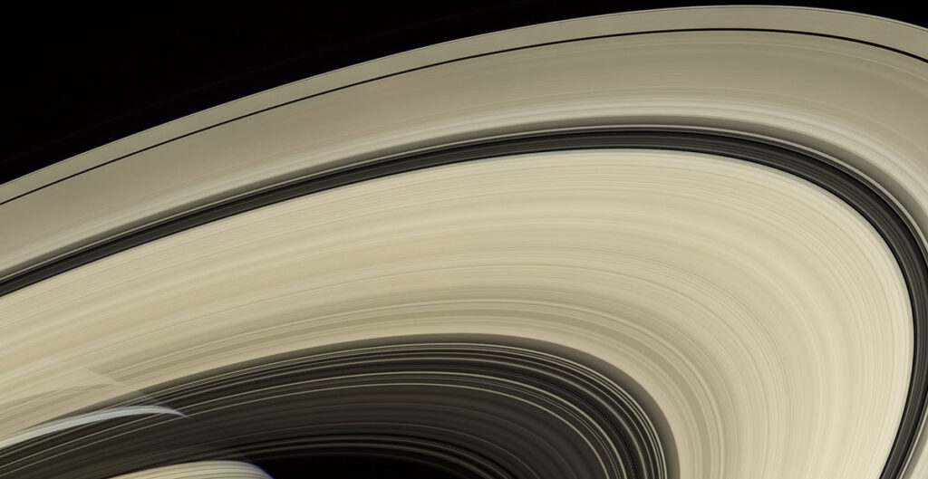 A close-up view of Saturn’s golden rings, which form many arcs around the planet.