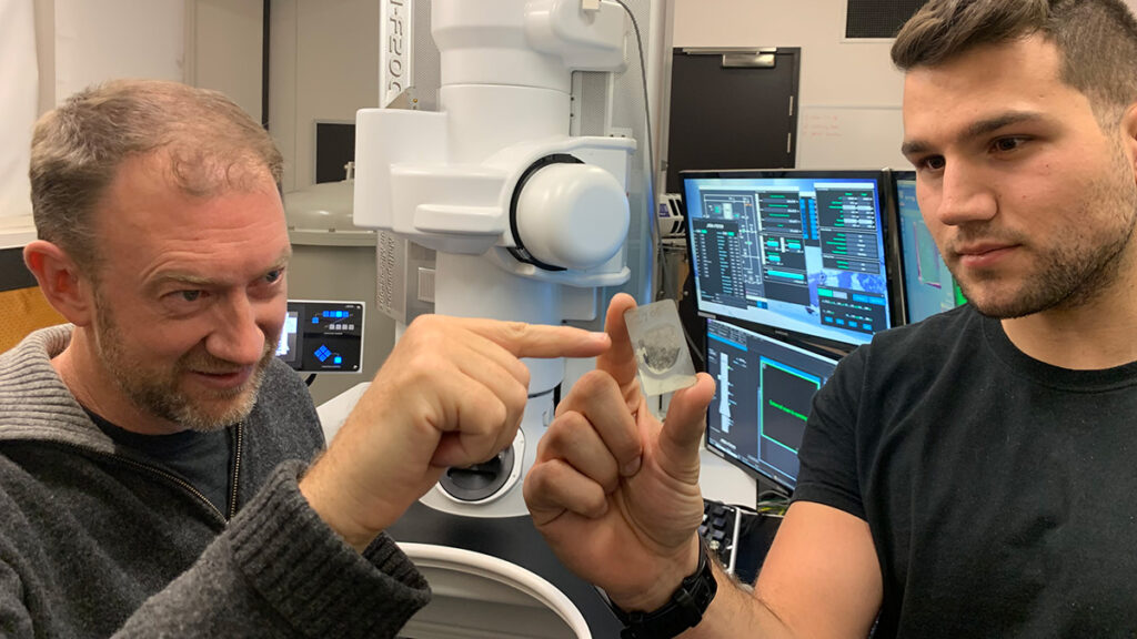 Monash University Professor Andrew Tomkins (left) and Royal Melbourne Institute of Technology (RMIT) Ph.D. scholar Alan Salek examine a ureilite meteorite sample at the RMIT Microscopy and Microanalysis Facility.