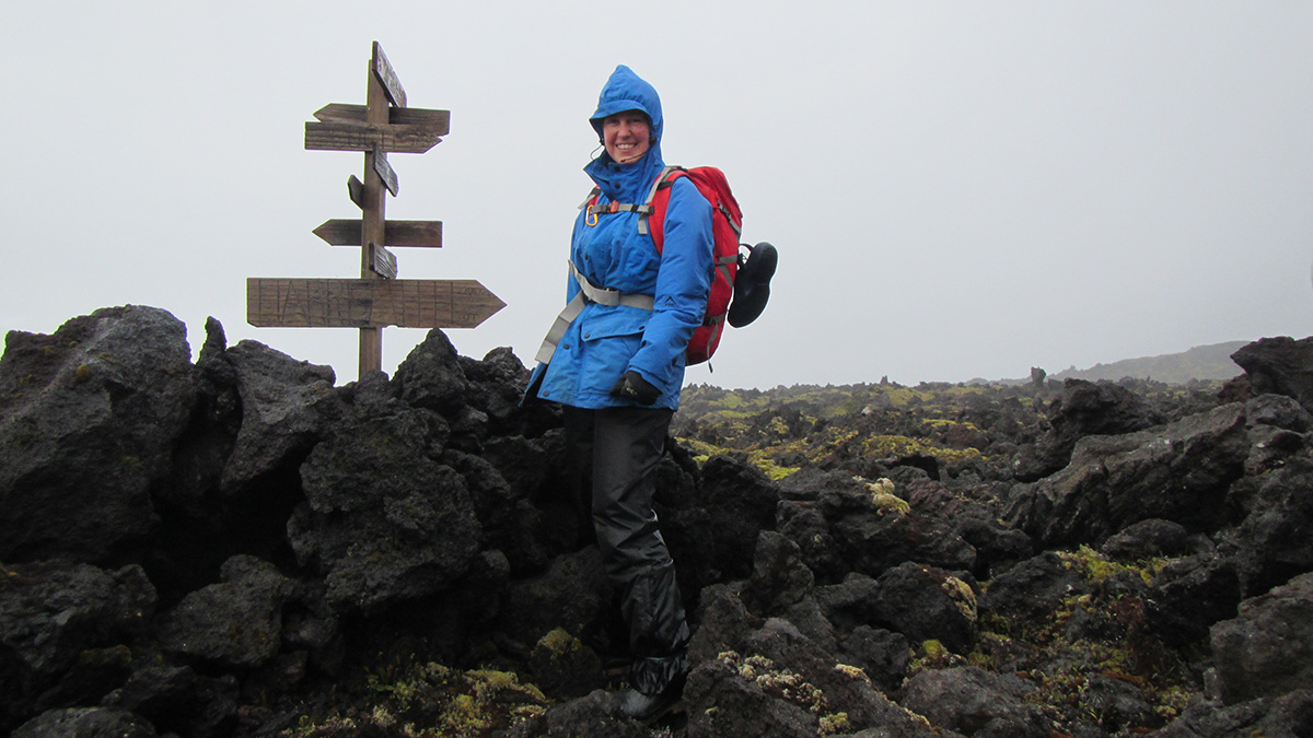 Researcher Liezel Rudolph stands next to an unmarked signpost on Marion Island.