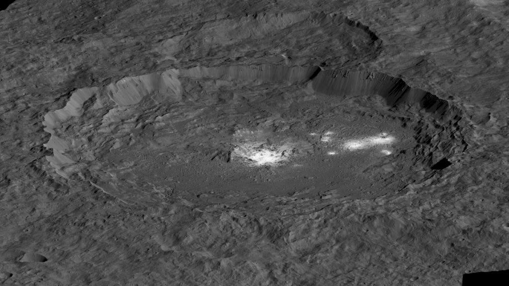 Bright spots dust the bottom of a dark crater on the dwarf planet Ceres.