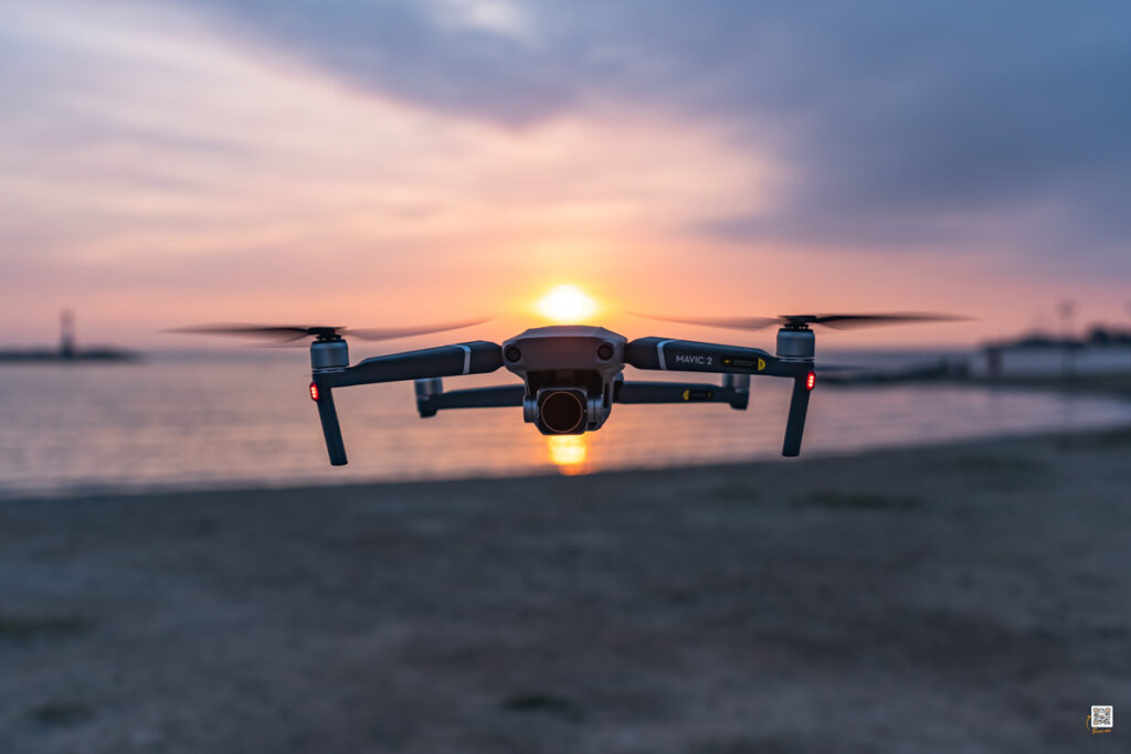 A drone hovers over a beach.