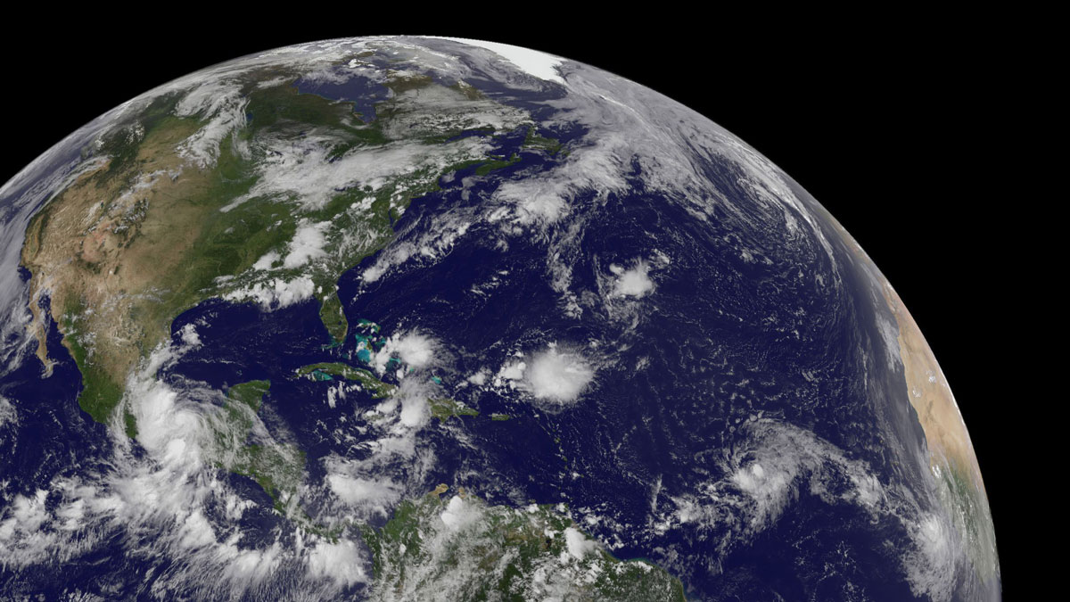Satellite image showing parts of Africa, North America, and South America, as well as several tropical storm systems over the Atlantic Ocean.