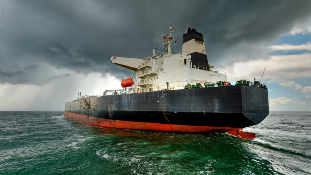 Black freighter at sea with gray, cloudy skies in the background