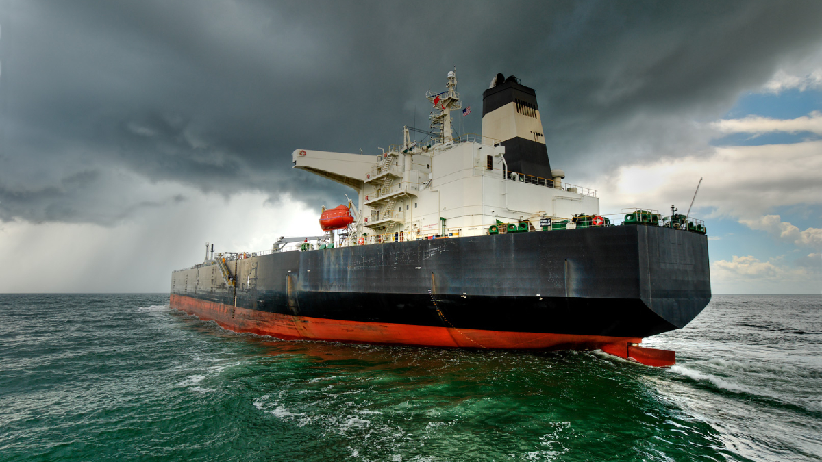 Black freighter at sea with gray, cloudy skies in the background