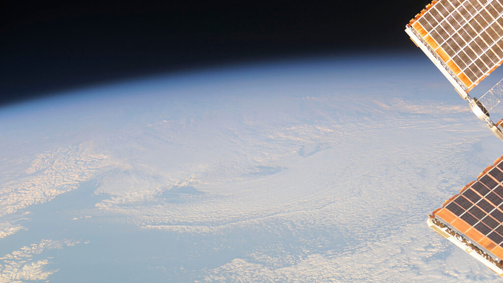 Aerial view of Earth with part of a satellite visible