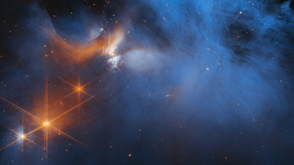 A large, dark cloud is contained within the frame. In its top half it is textured like smoke and has wispy gaps, whereas at the bottom and on the sides it fades gradually out of view. On the left are several orange stars: three each with six large spikes and one behind the cloud, which colors it pale blue and orange. Many tiny stars are visible, and the background is black.