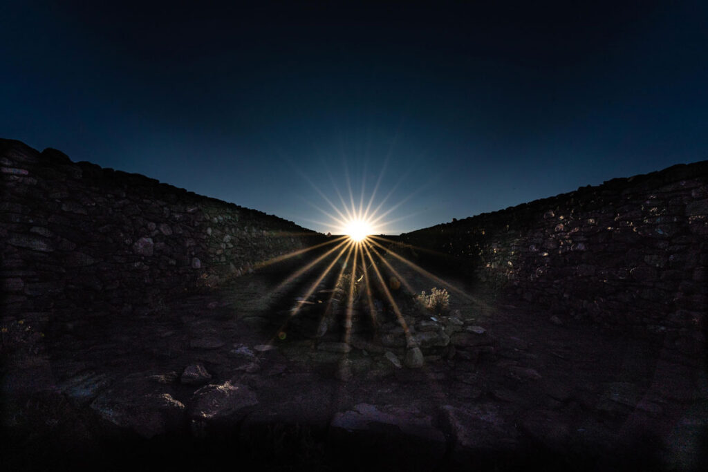 Photo of Sun rising between two hills.