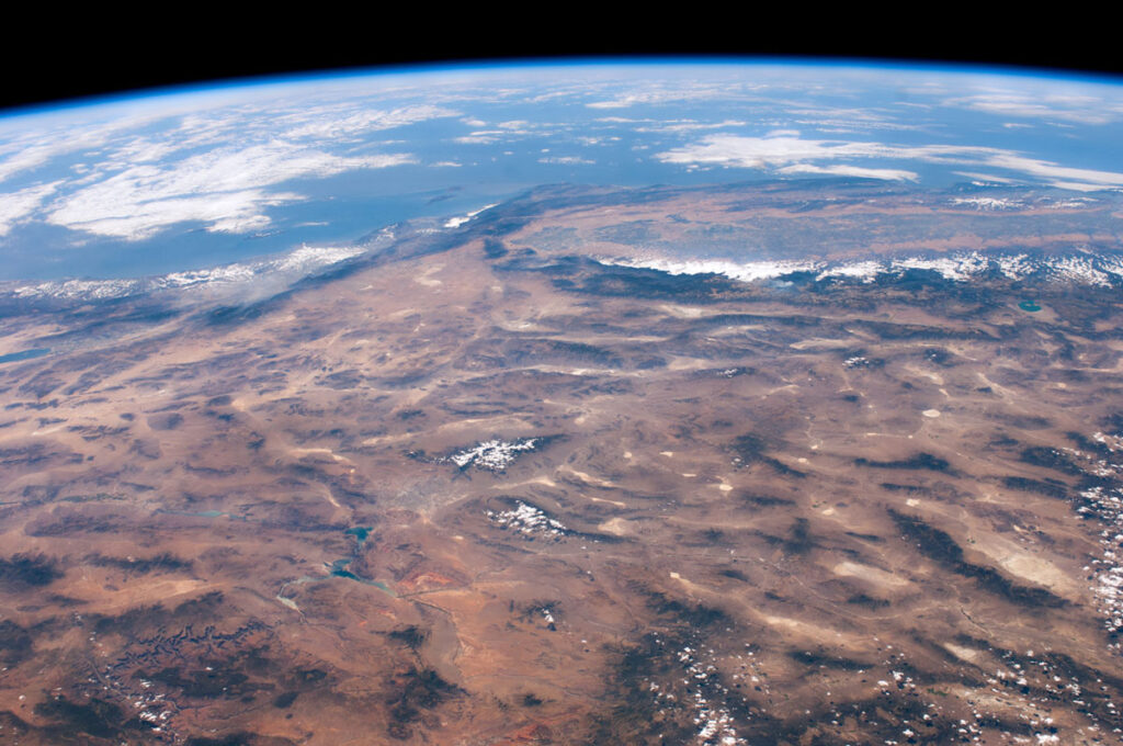 A satellite photo of a brown landscape with parallel dark lines.