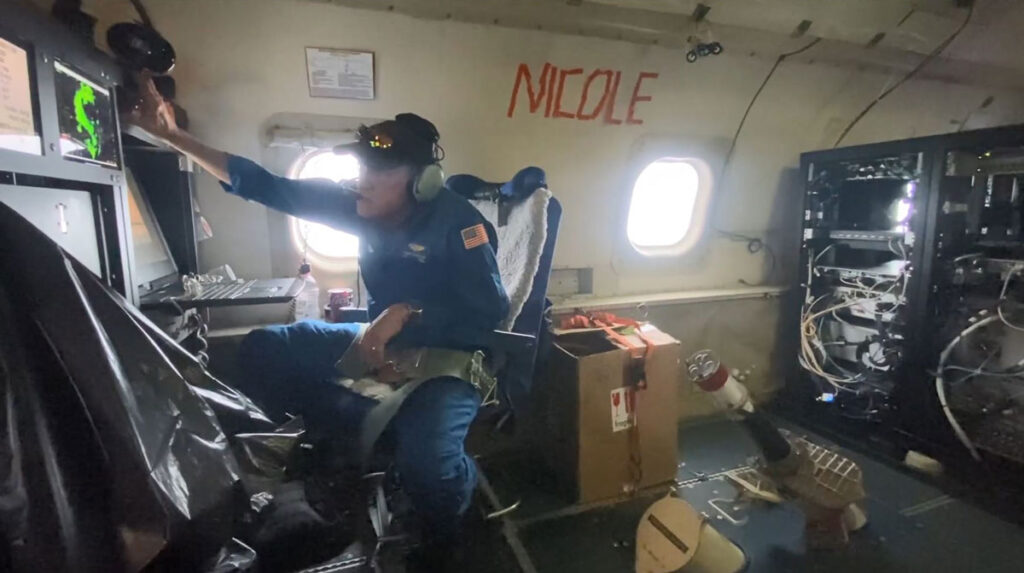 A photo of a person touching equipment inside an airplane.