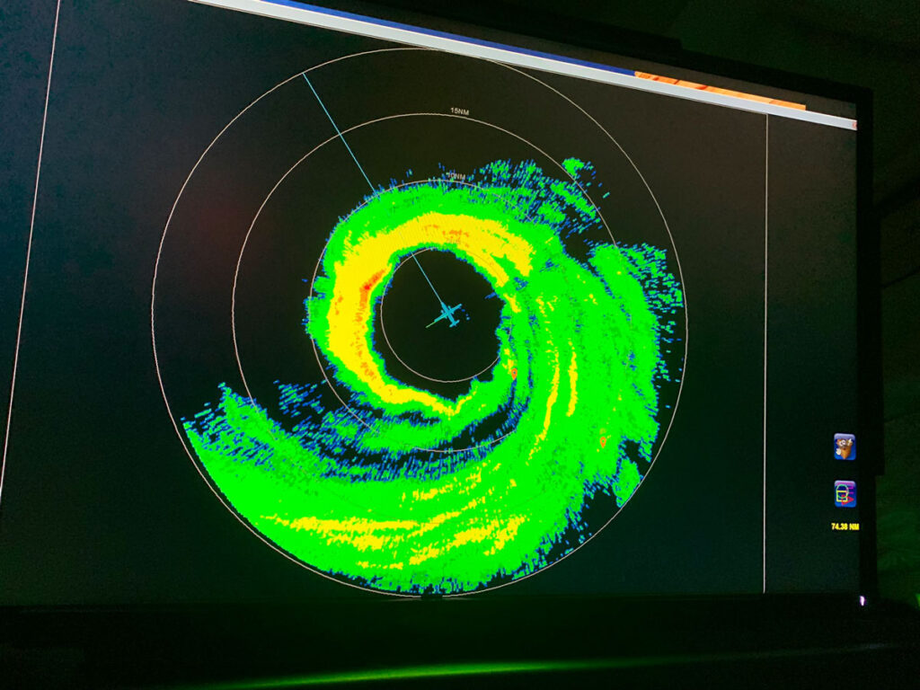 A black screen with a circular swirl of green and yellow colors.