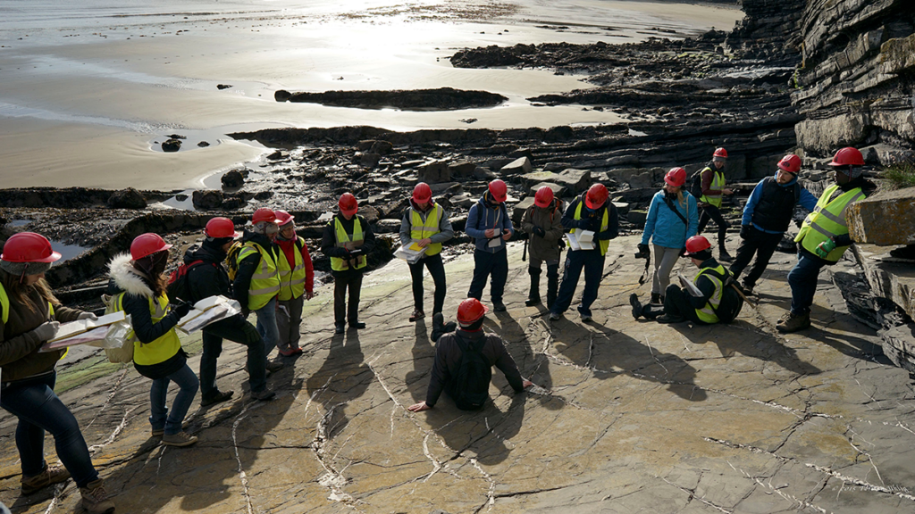 A group of geoscientists on a rock outcrop.