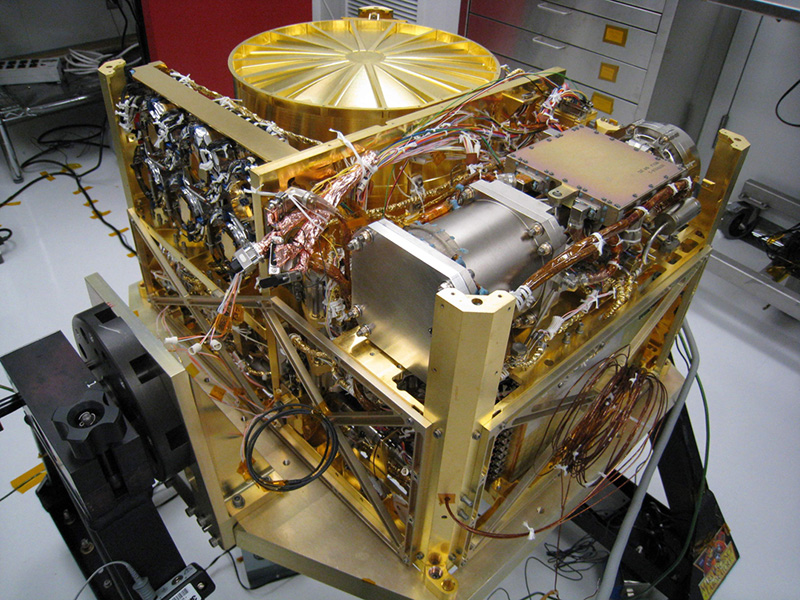 A rectangular, gold colored, metal box with tubes and instruments