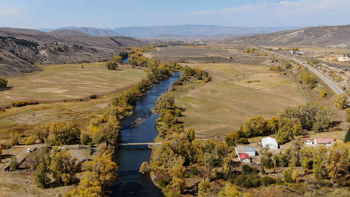 An aerial image of a river flowing through fields of green