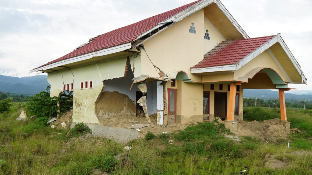 A house has gaping holes in its sides as a result of earthquake damage.