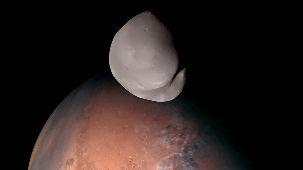 A close-up of a smooth gray semispherical body in space with a red spherical body in the background
