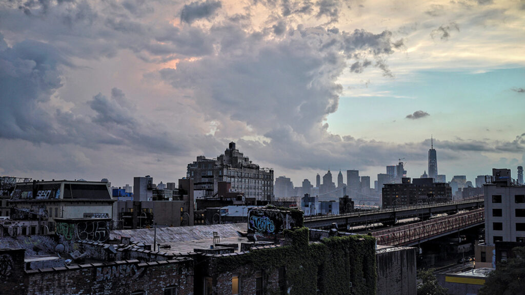 Una foto de cielos nublados sobre edificios y rascacielos de ladrillo.