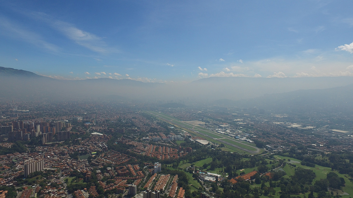 Hazy clouds obscure most of the view of a developed valley.