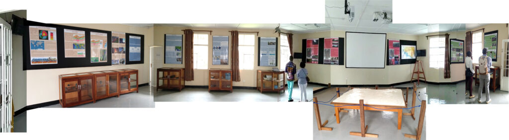 Una foto panorámica unida de una habitación con ventanas y carteles con texto e imágenes colgados en la pared.