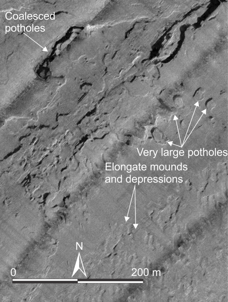 Gray-and-white image of the seafloor shows circular features on the bedrock. Text on the image says “Coalesced potholes,” “Very large potholes,” and “elongated mounds and depressions,” with arrows pointing to examples.