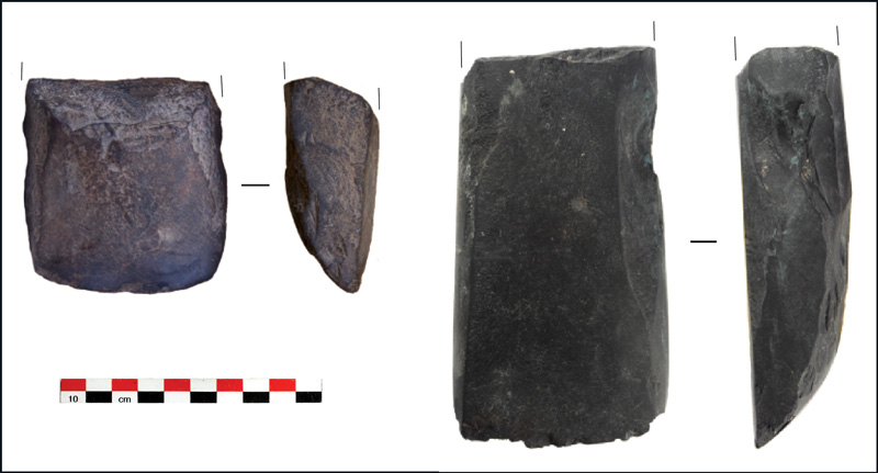 Two adzes made of dark stone. The adzes are approximately 8 and 15 centimeters (3.5 and 6 inches) in length.