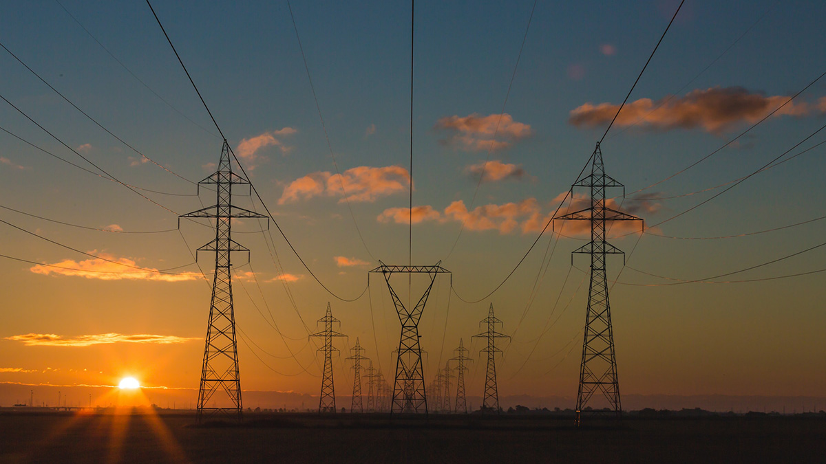 High-voltage electrical transmission lines seen at sunset