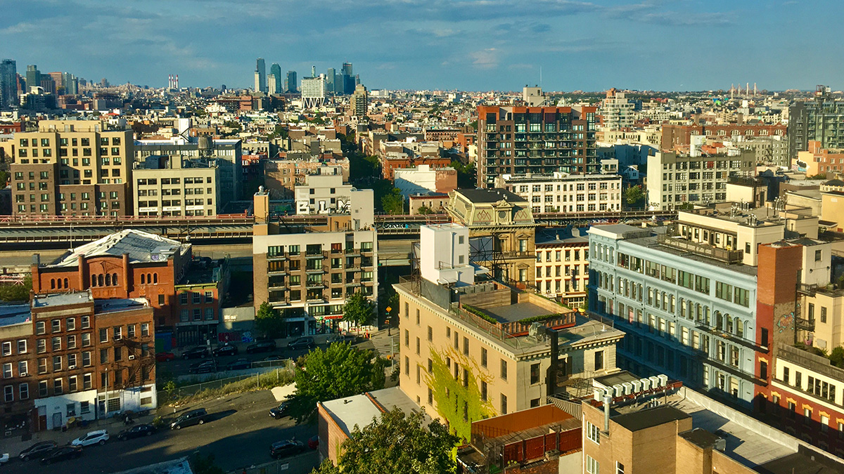 View of varying style brick buildings in a city as seen from near the top of a building
