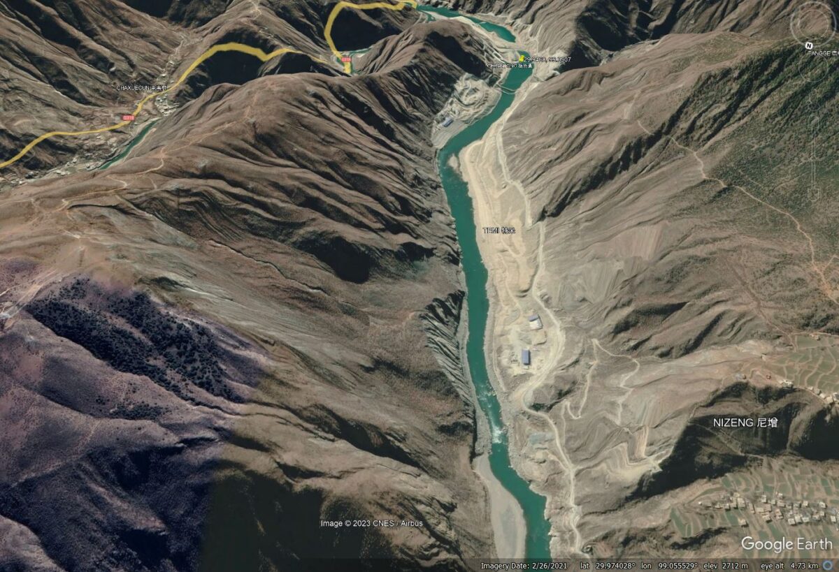 Google Earth perspective view showing the Temi landslide in the foreground and the Batong hydropower station about 4 km downstream.