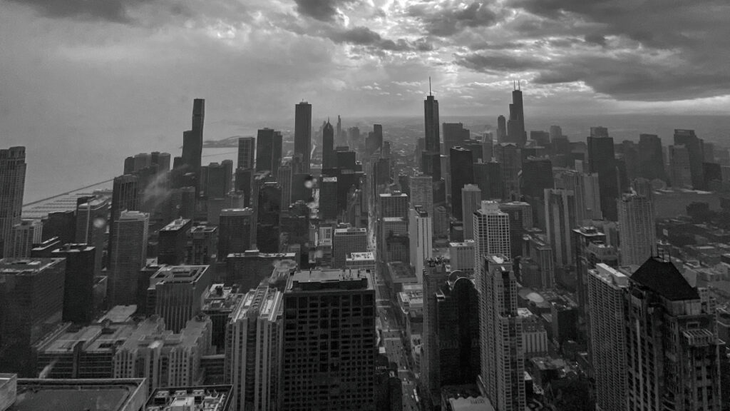 A grayscale image of the Chicago Loop photographed from the 94th floor of the Hancock building.