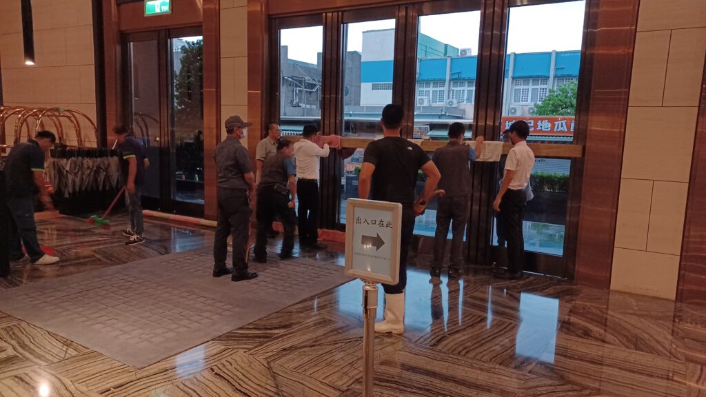 Staff at the Sheraton Hotel barricading the front doors ahead of the arrival of Typhoon Haikui.