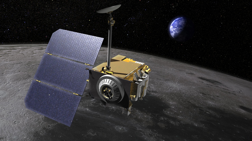 A spacecraft with solar panels extending off one side flies over the dark surface of the Moon with Earth in the background.