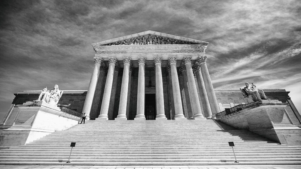 Black and white photo looking up the steps of the U.S. Supreme Court building