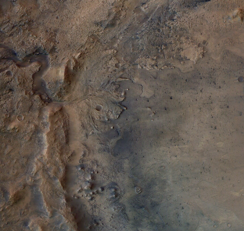 Satellite image of a brown and gray landscape with a winding dry river that leads to several smaller channels.