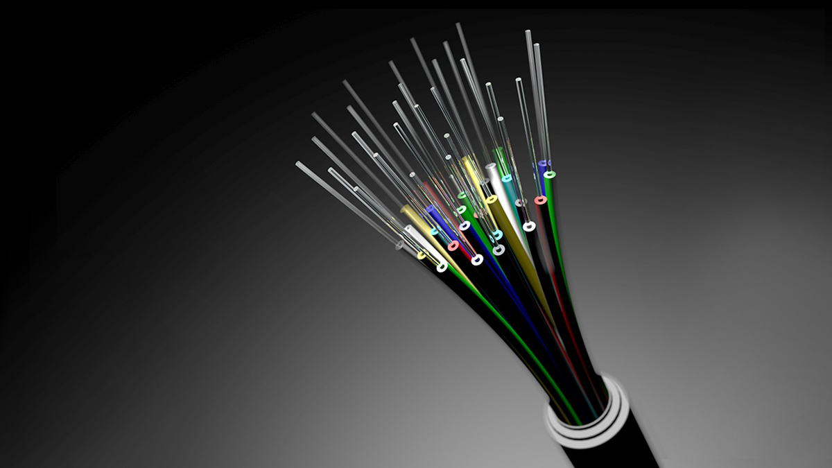 A close-up view of a fiber-optic cable. One main cable is filled with smaller glass strands that are pathways through which light communications pass and transmit data.