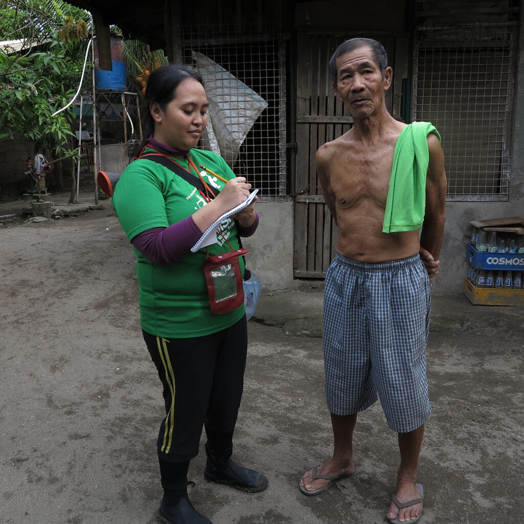 A researcher interviews a village elder.